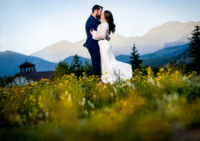 Bride and groom portrait in a field of flowers with the mountains in the background | Estes Park Fall Wedding YMCA of the Rockies