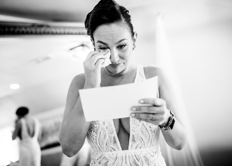 A bride tears up reading a letter during her wedding at Boulder Creek Wedgewood