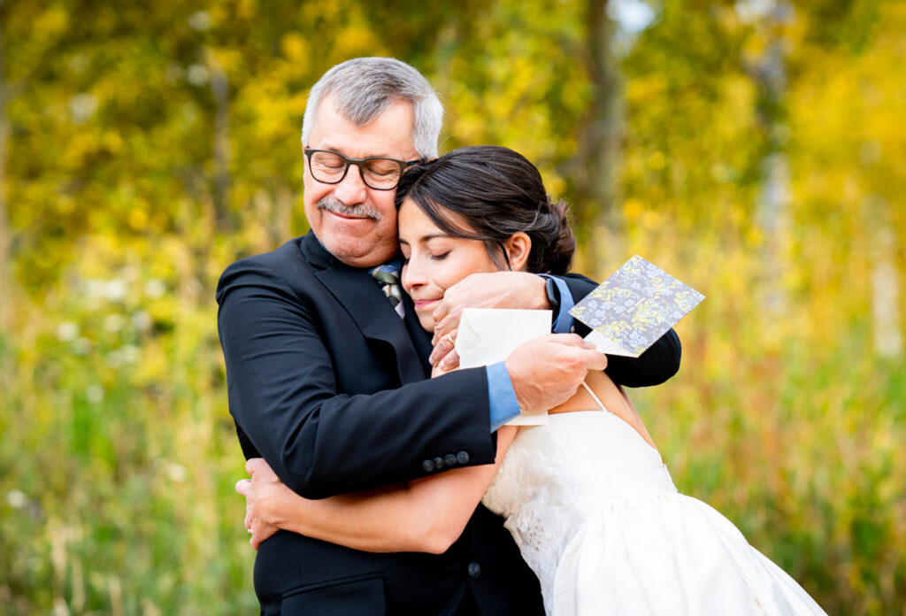 Bride shares a hug with her dad during their first look at Dao House Retreat in Estes Park