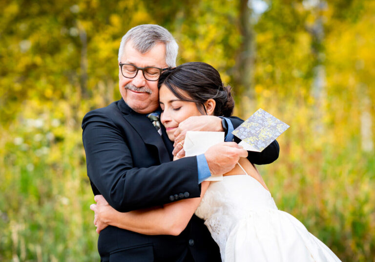 A bride shares a hug with her dad during their first look at Dao House Retreat in Estes Park