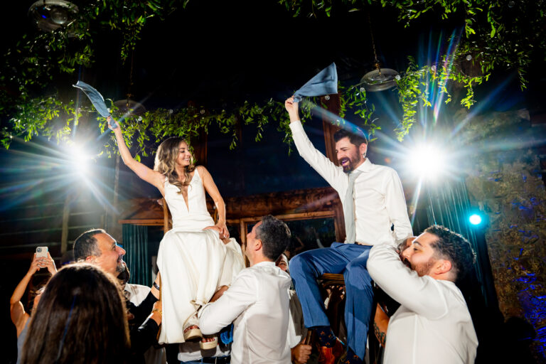 Bride and groom lifted in chairs during wedding reception at Dao House Retreat in Estes Park, Colorado.