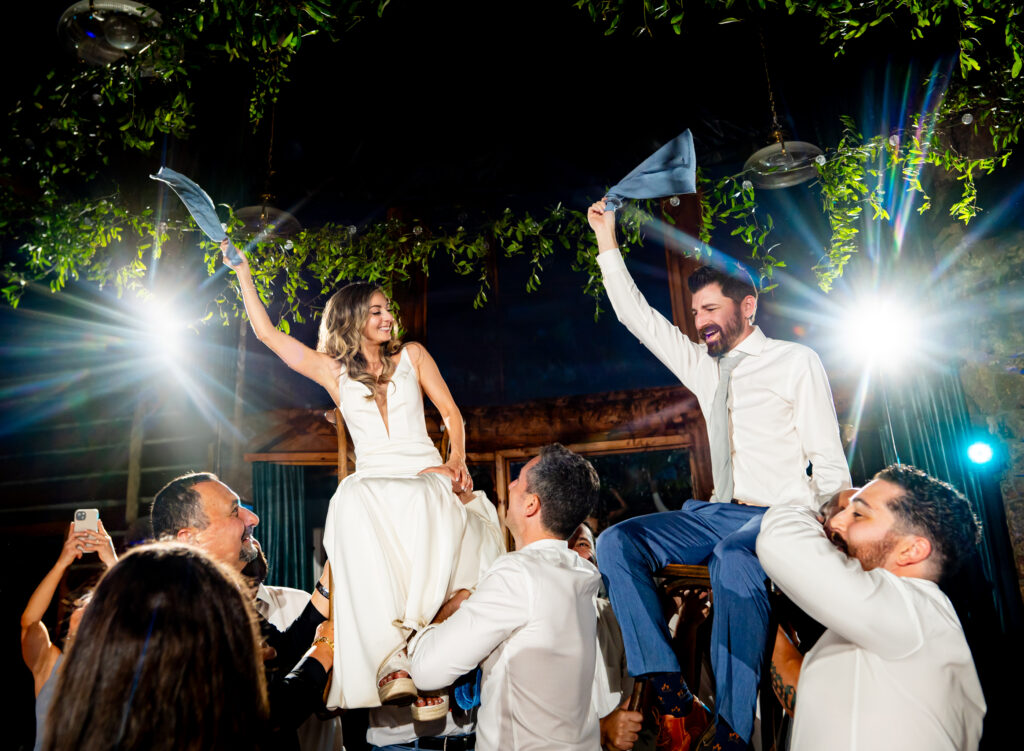 Bride and groom lifted in chairs during wedding reception at Dao House Retreat in Estes Park, Colorado.