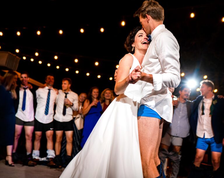 A bride laughs as her groom dances with her with his pants around his ankles, captured in a candid documentary wedding photography style at Arum in Steamboat Springs, Colorado