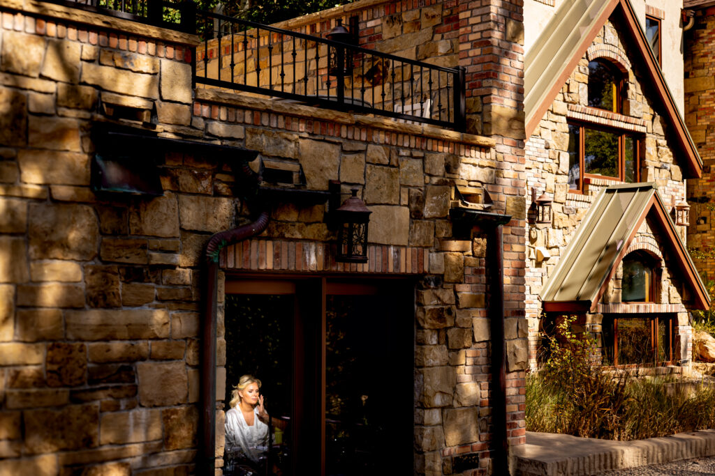 Seen from outside, a bride gets her makeup done inside Della Terra Mountain Chateau during her wedding