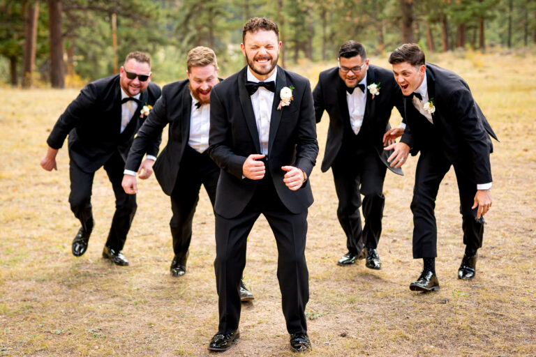 A groom anxiously waits to be tackled by his groomsmen during his Della Terra Mountain Chateau wedding