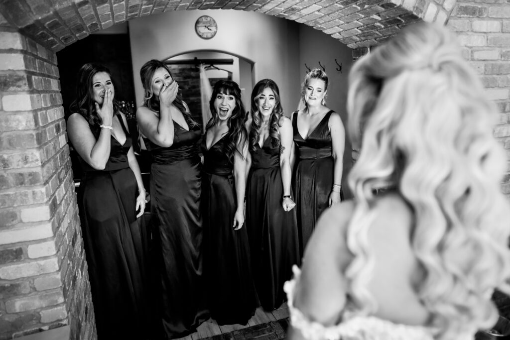 Bridesmaids gasp in excitement during a first look with their bride during a Della Terra Mountain Chateau wedding