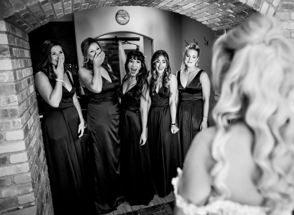 Bridesmaids gasp in excitement during a first look with their bride during a Della Terra Mountain Chateau wedding