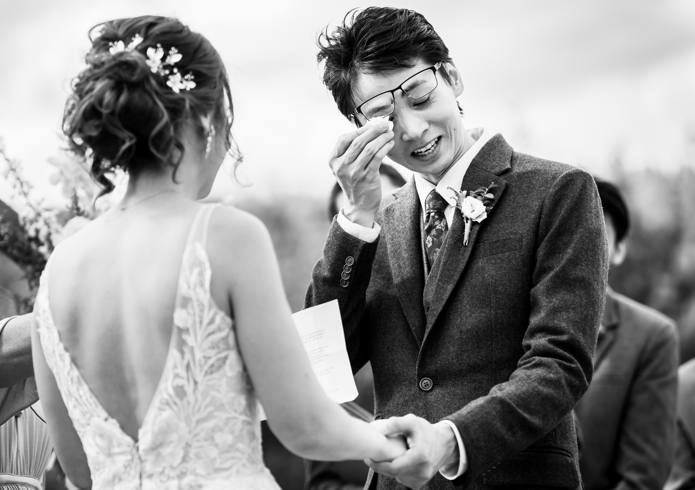 Groom wipes away a tear during their wedding ceremony at Wild Basin Lodge