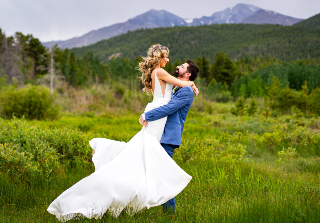 A bridge and groom embrace at Lily Lake in Estes Park during their Dao House wedding