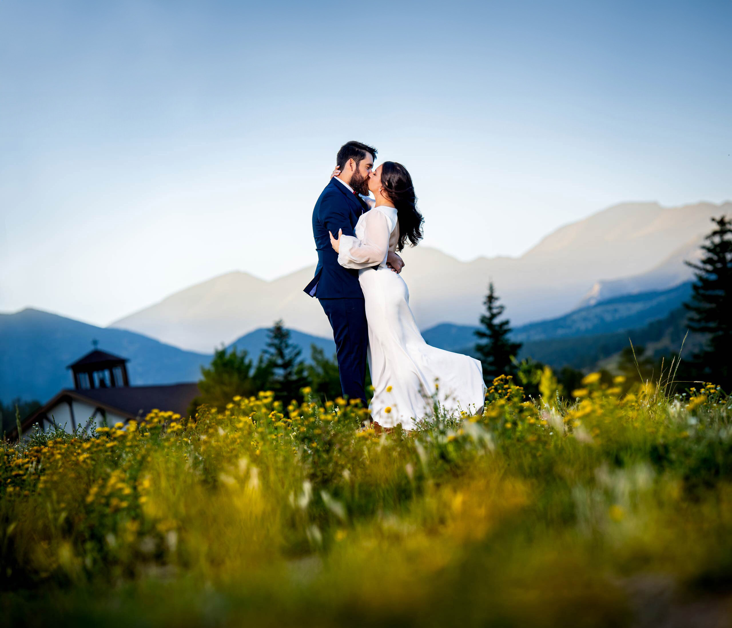 A bride and groom embrace in a kiss for a documentary-style wedding portrait at the YMCA of the Rockies in Estes Park