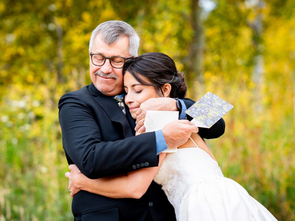 A bride shares a hug with her dad during their first look at Dao House Retreat in Estes Park