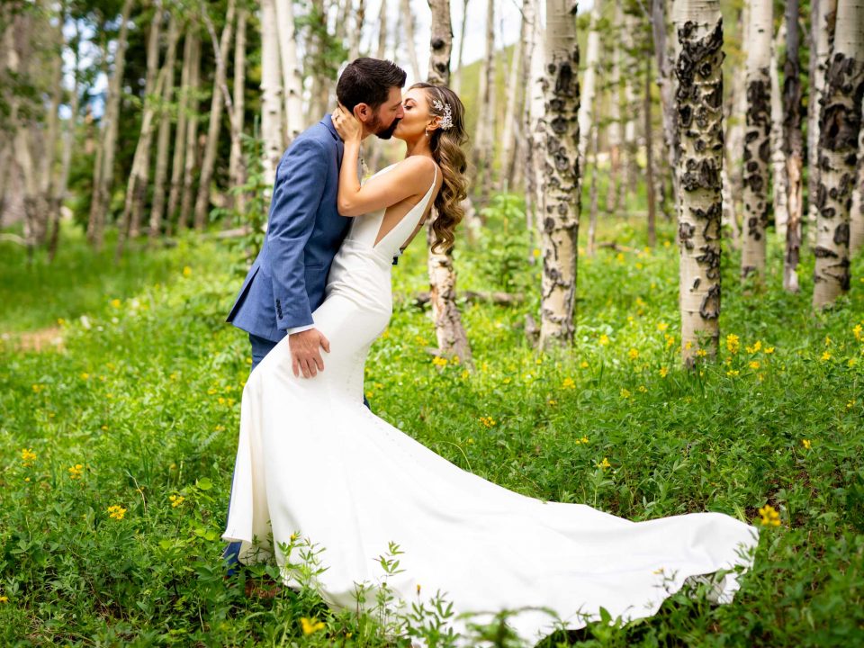 A bride and groom embrace amid aspen trees during their Dao House wedding