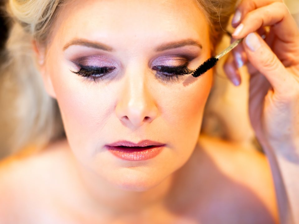 A bride gets her makeup done during her Della Terra Mountain Chateau wedding