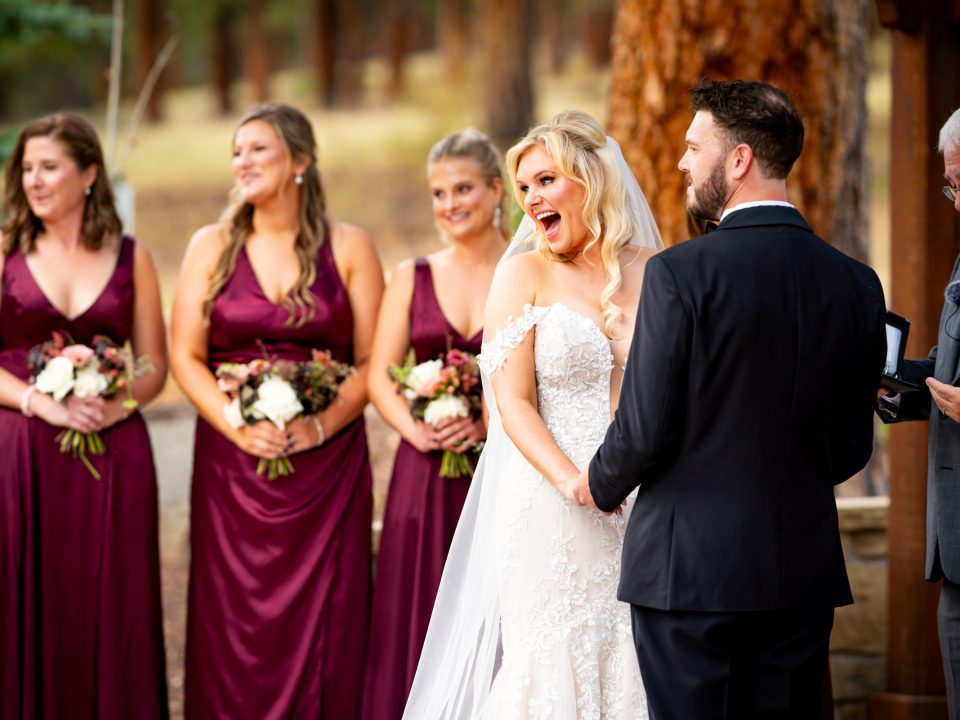 A bride playfully gasps while looking at her infant son during her wedding ceremony at Della Terra Mountain Chateau