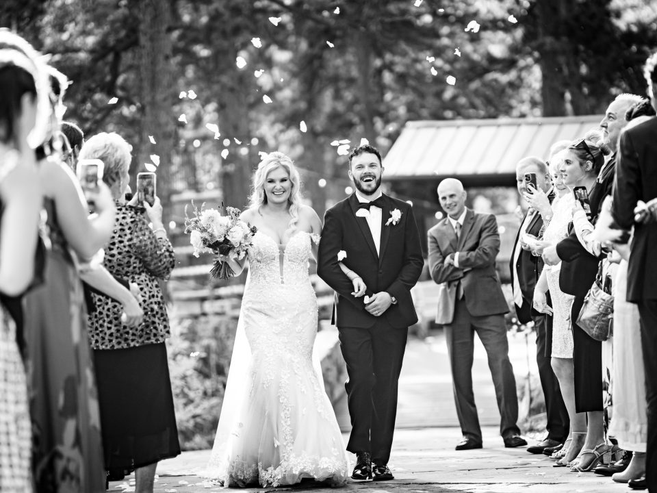 A joyful bride and groom smile during the recessional of their Della Terra Mountain Chateau wedding