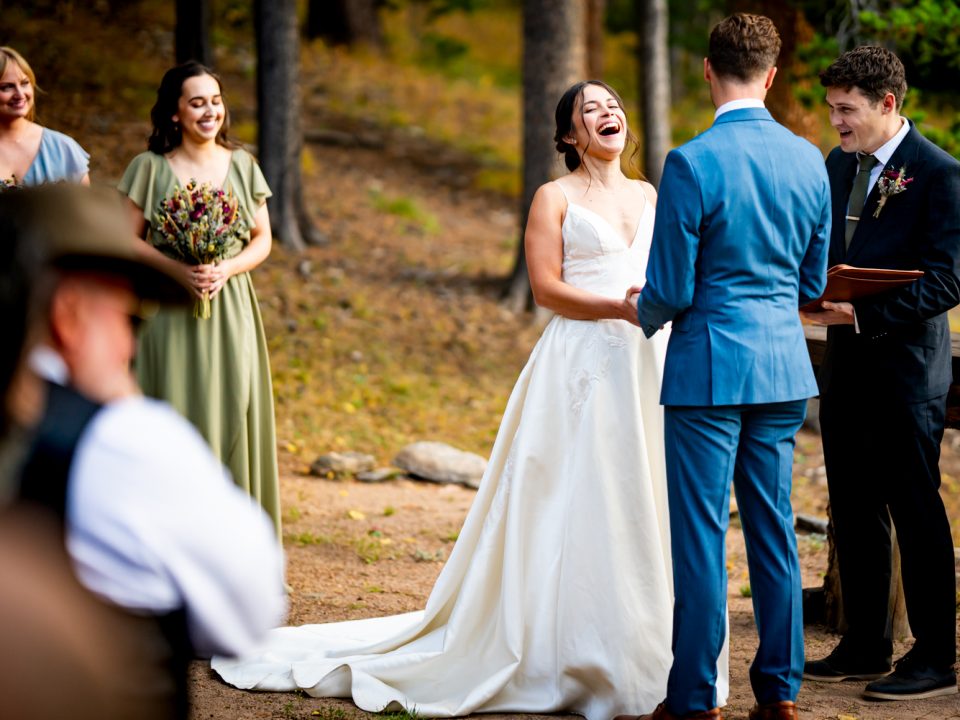 A bride laughs during her partner's vows at the Dao House wedding ceremony site