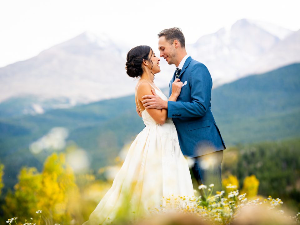 A bride and groom embrace with Longs Peak in the background during portraits at their Dao House wedding