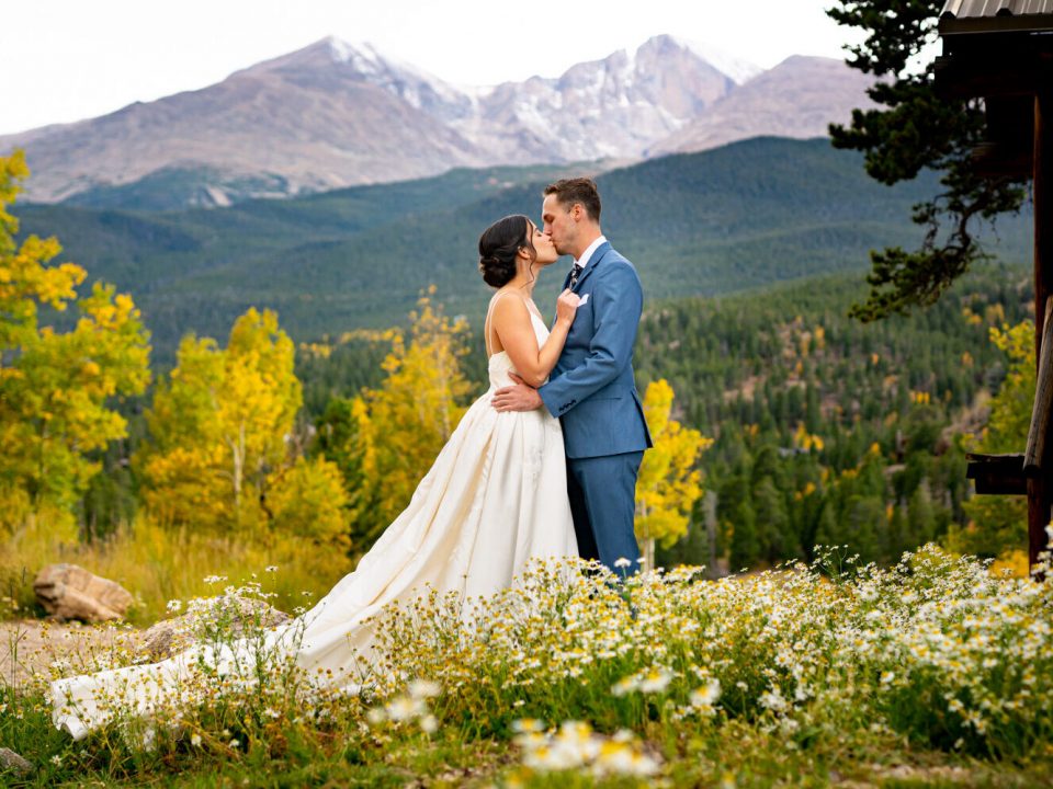 A bride and groom kiss amid golden aspen trees during a Dao House wedding