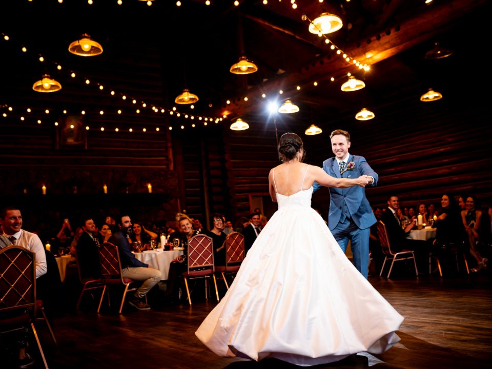 A bride and groom share their first dance in the reception hall of Dao House in Estes Park